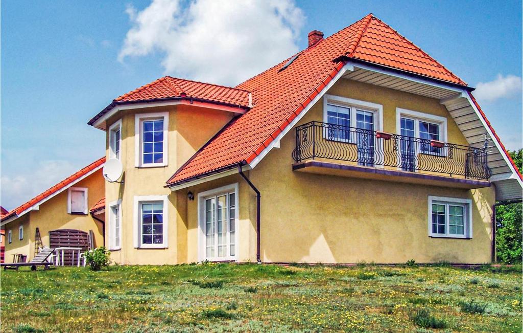 ein gelbes Haus mit orangefarbenem Dach in der Unterkunft Cozy Home In Kamien With Kitchen in Kamień