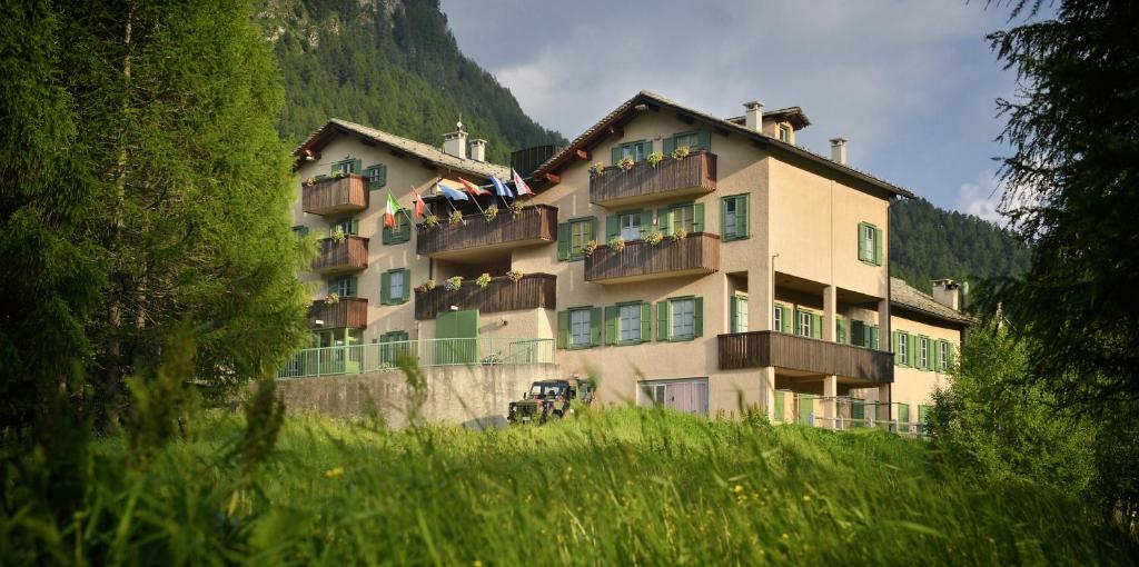 a large building with people on the balconies of it at Albergo Casa Alpina San Luigi in Campodolcino