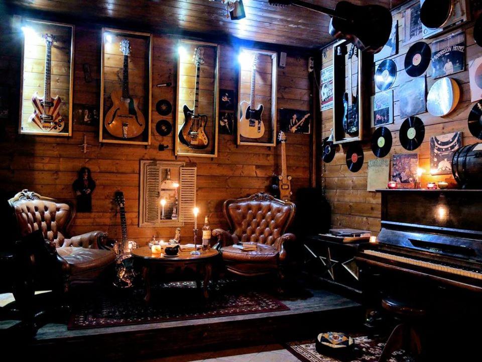 une chambre avec un piano, des chaises et une table dans l'établissement Pirola Music Ranch Guest House B&B, à Romano di Lombardia