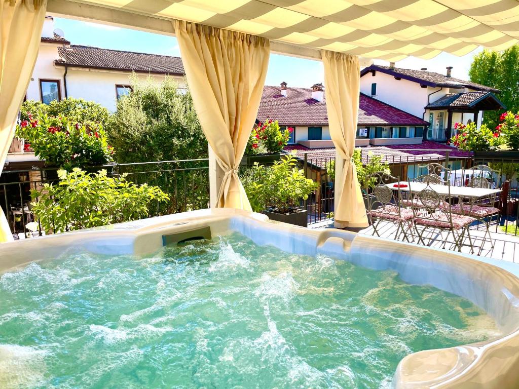 una vasca idromassaggio su un patio con di Dimora di Charme Rooms & Apartments a Peschiera del Garda