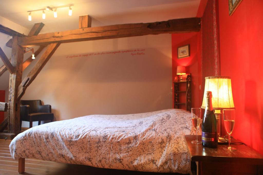 een slaapkamer met een bed en een rode muur bij Gite ferme XVIII 4 chambres /8 personnes Chimay in Momignies