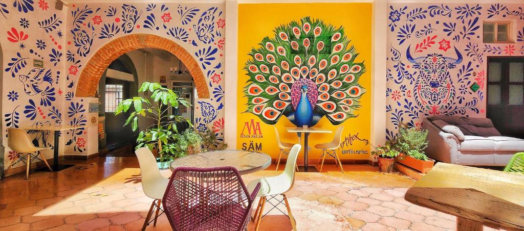 una habitación con una mesa y sillas con una pintura en la pared en MESON AMELIA en San Miguel de Allende