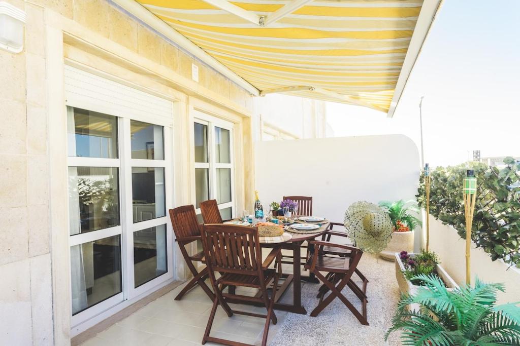 eine Terrasse mit einem Tisch und Stühlen auf dem Balkon in der Unterkunft Best Houses 36 - Baleal Surf Village in Peniche