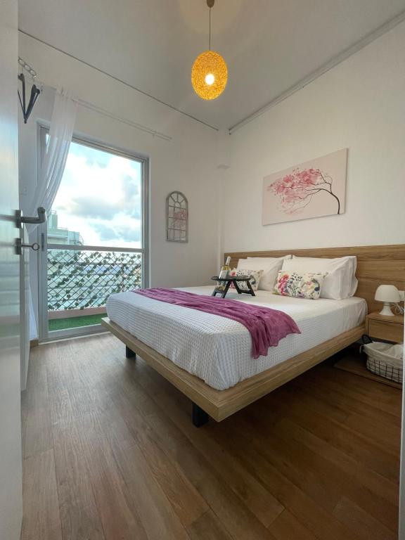 1 dormitorio con cama grande y ventana grande en Sakura Dntwn, en Heraclión