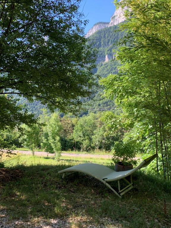 a bench in the middle of a field with trees at La coccinelle in Noyarey