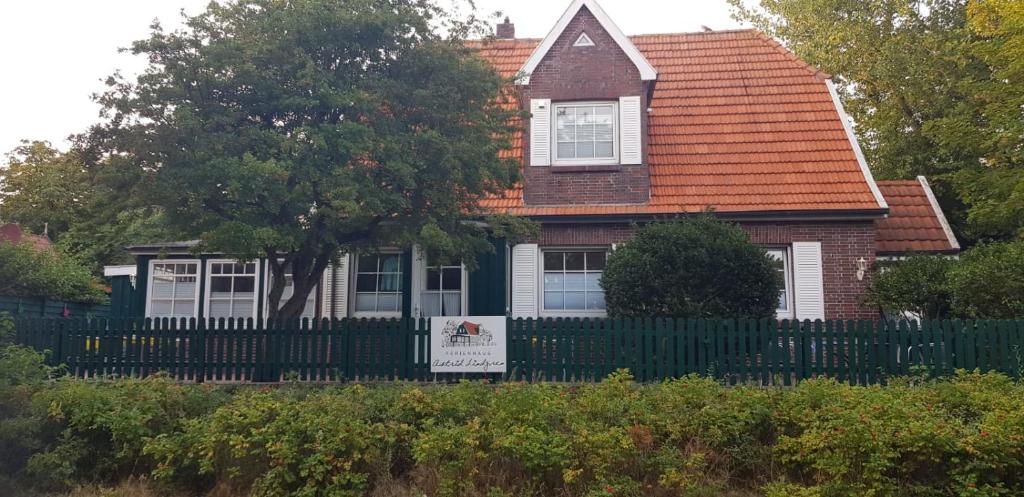 dom z płotem i znakiem przed nim w obiekcie Ferienhaus Astrid Lindgren w mieście Spiekeroog