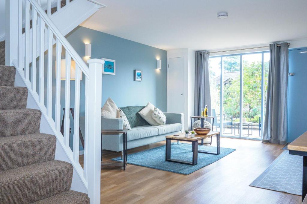 a living room with a couch and a staircase at Mousehole in Mawnan