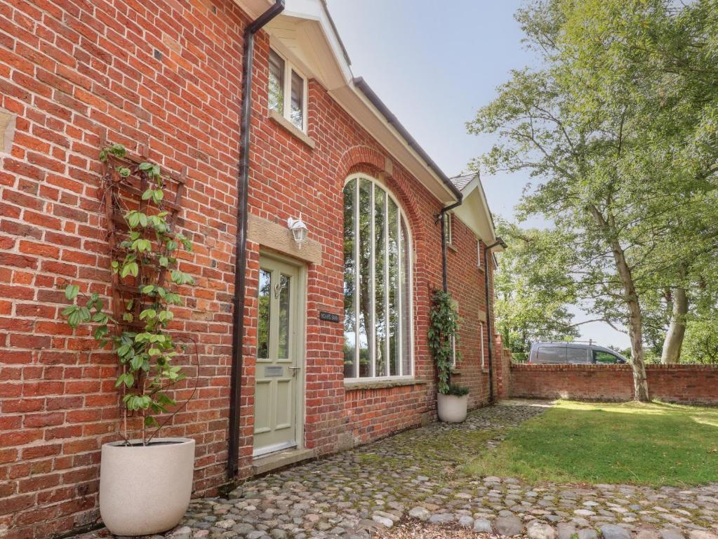 a brick house with two potted plants in front of it at Noah's Barn in Poulton le Fylde