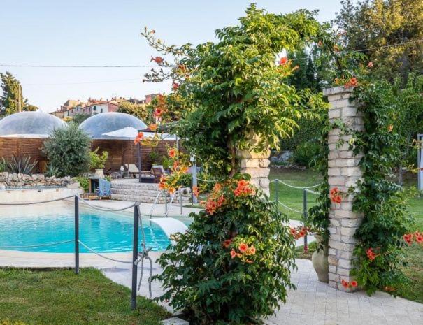einen Garten mit Pool und ein paar Blumen in der Unterkunft l' Acciuga Blu in Monte Marcello