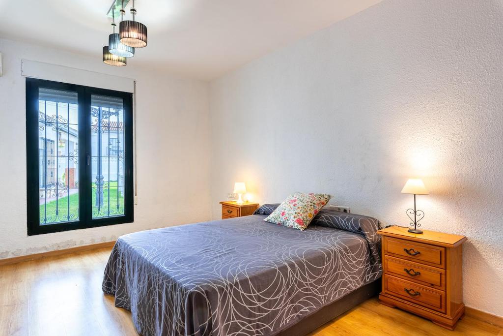 een slaapkamer met een bed en een raam bij Villa espectacular in Rincón de la Victoria