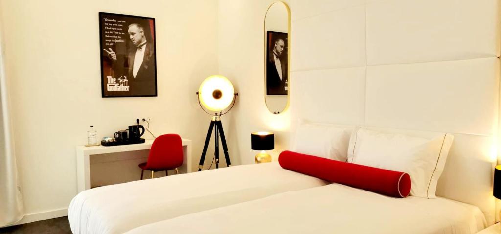 - une chambre avec un lit blanc et un oreiller rouge dans l'établissement Lisbon City Hollywood Hotel by City Hotels, à Lisbonne