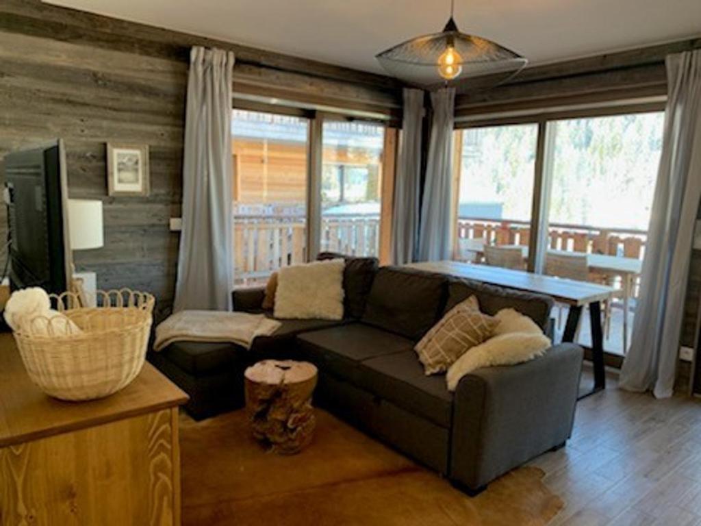 ein Wohnzimmer mit Sofa und Tisch in der Unterkunft Charmant appart 4 pers avec balcon, parking & WiFi - FR-1-198-211 in Châtel