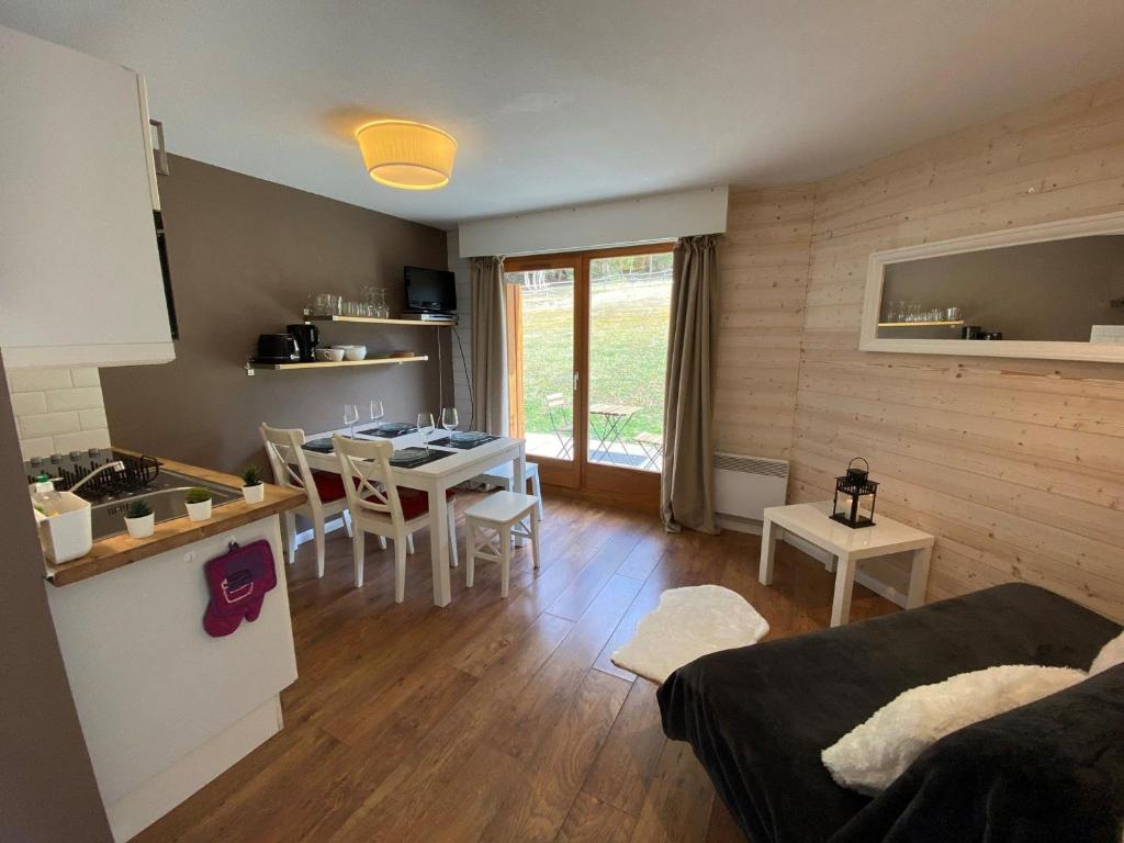 - un salon avec une cuisine et une table avec des chaises dans l'établissement Appartement moderne avec terrasse et parking, près des pistes, pour 6 personnes - FR-1-198-217, à Châtel