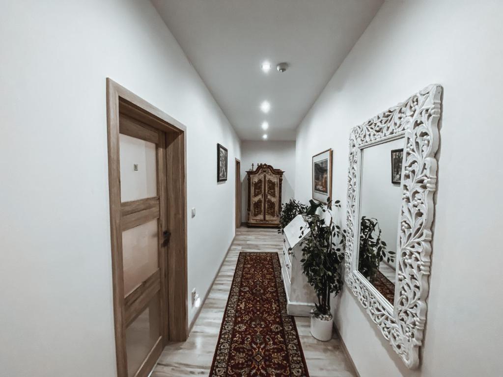 a hallway with a door and a mirror and a rug at Cozy B&B Home in Banská Bystrica