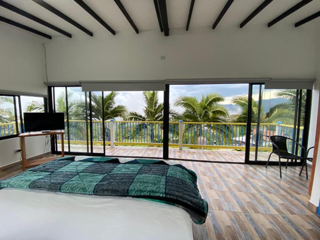 1 dormitorio con 1 cama grande y balcón en Cabañas y Flores en Jericó