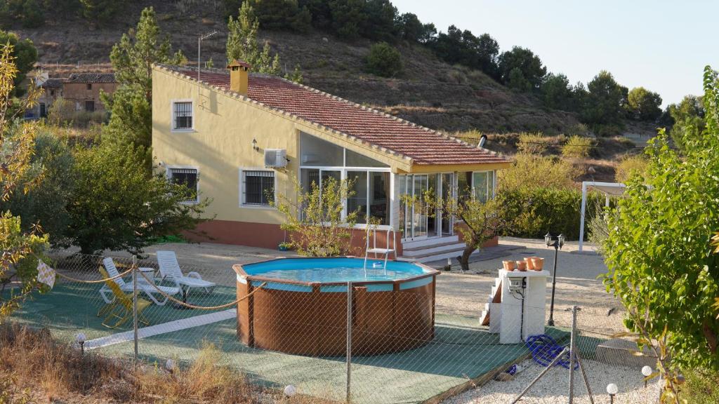 una casa con piscina frente a una casa en LA ANTIGUA CASA DEL ASTRONOMO Casa Rural en Ricote