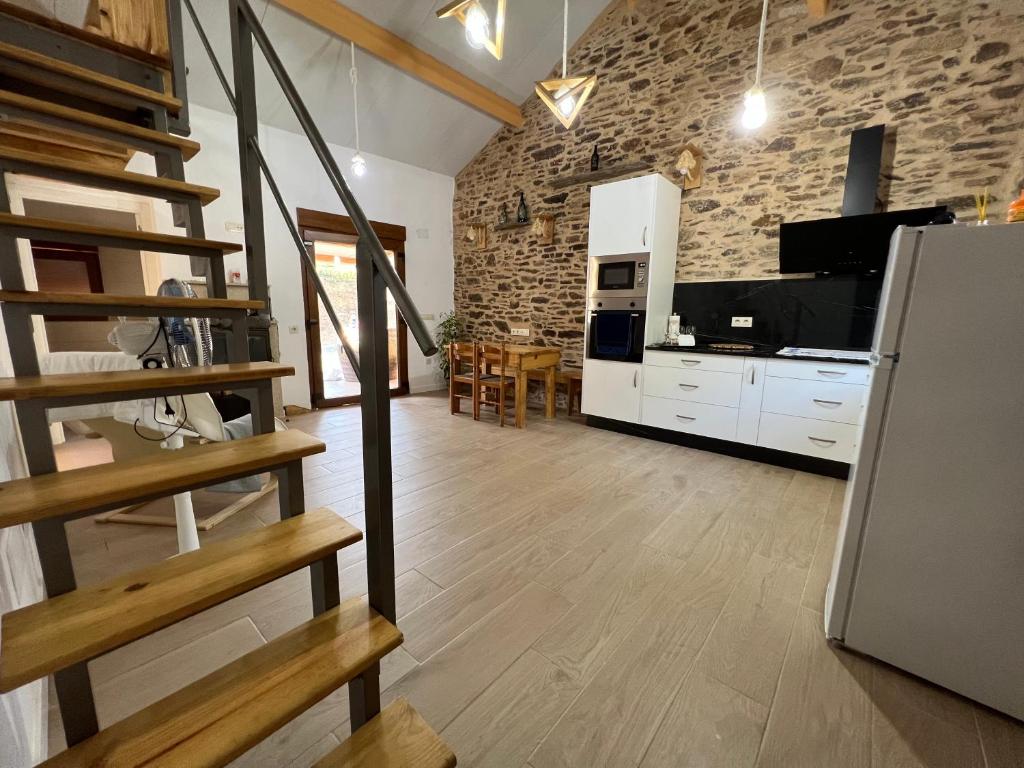 Il comprend un salon avec un escalier et une cuisine. dans l'établissement Casa de piedra Barreiriña, à A Coruña