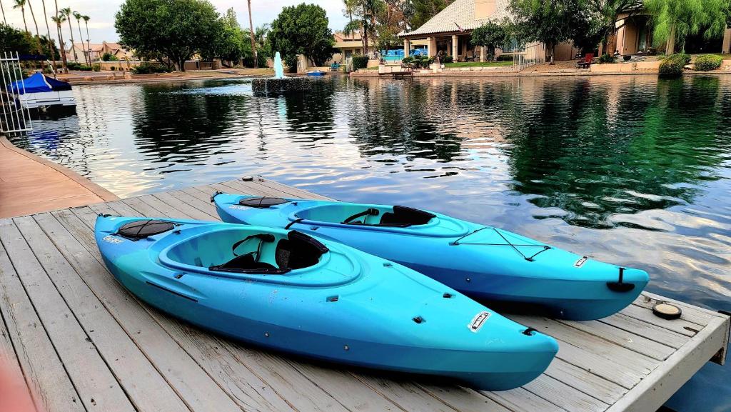 tres barcos azules sentados en un muelle en el agua en PEACEFUL lakeside home, minutes from Downtown Gilbert, en Gilbert
