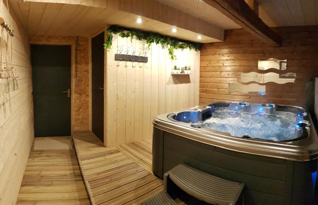 a jacuzzi tub in the middle of a room at Gîte et SPA Chez Jules in Vellerot-lès-Vercel