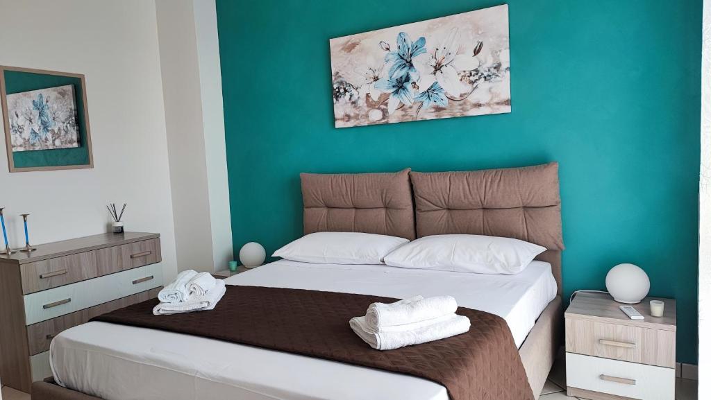 sypialnia z dużym łóżkiem z niebieskimi ścianami w obiekcie NickyHouse Holiday Home w mieście Giffoni Sei Casali