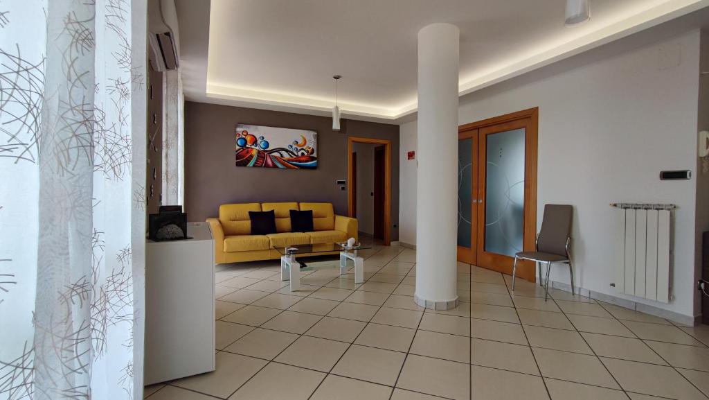 salon z żółtą kanapą i stołem w obiekcie NickyHouse Holiday Home w mieście Giffoni Sei Casali
