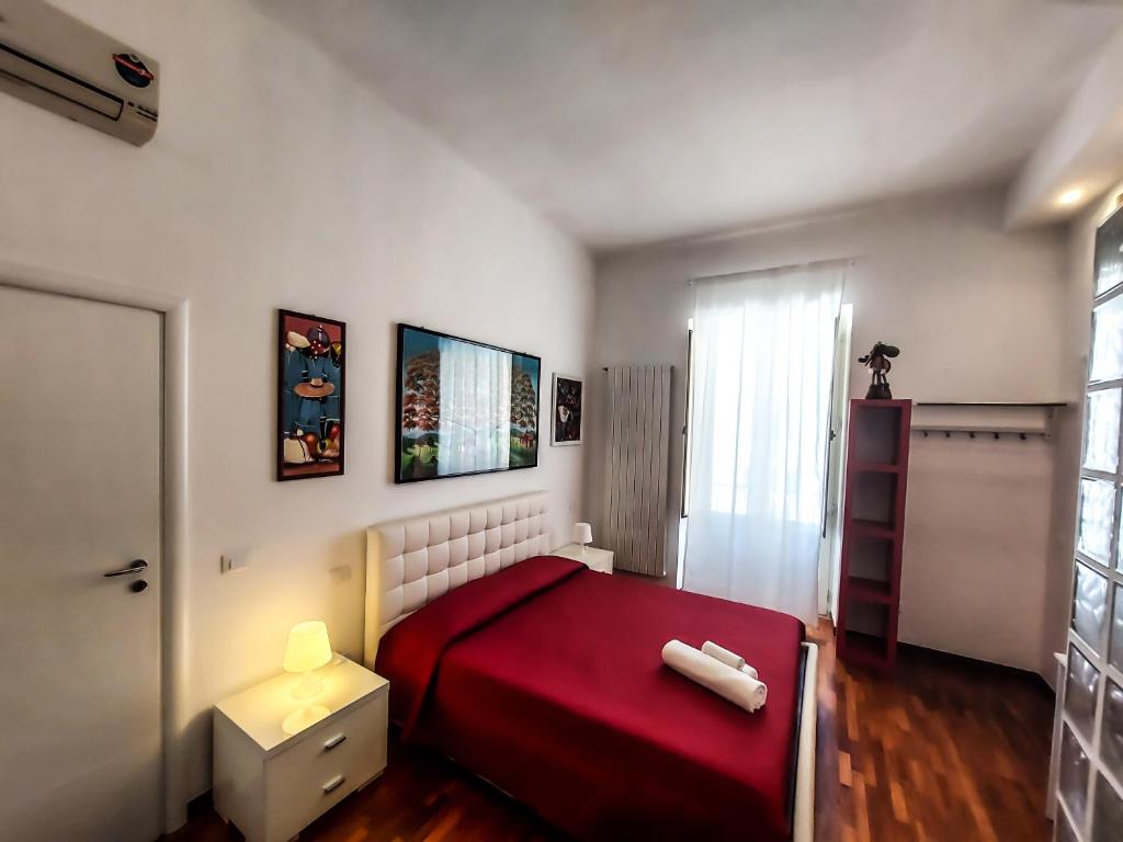 a small bedroom with a red bed and a window at Casa Flora in Taranto