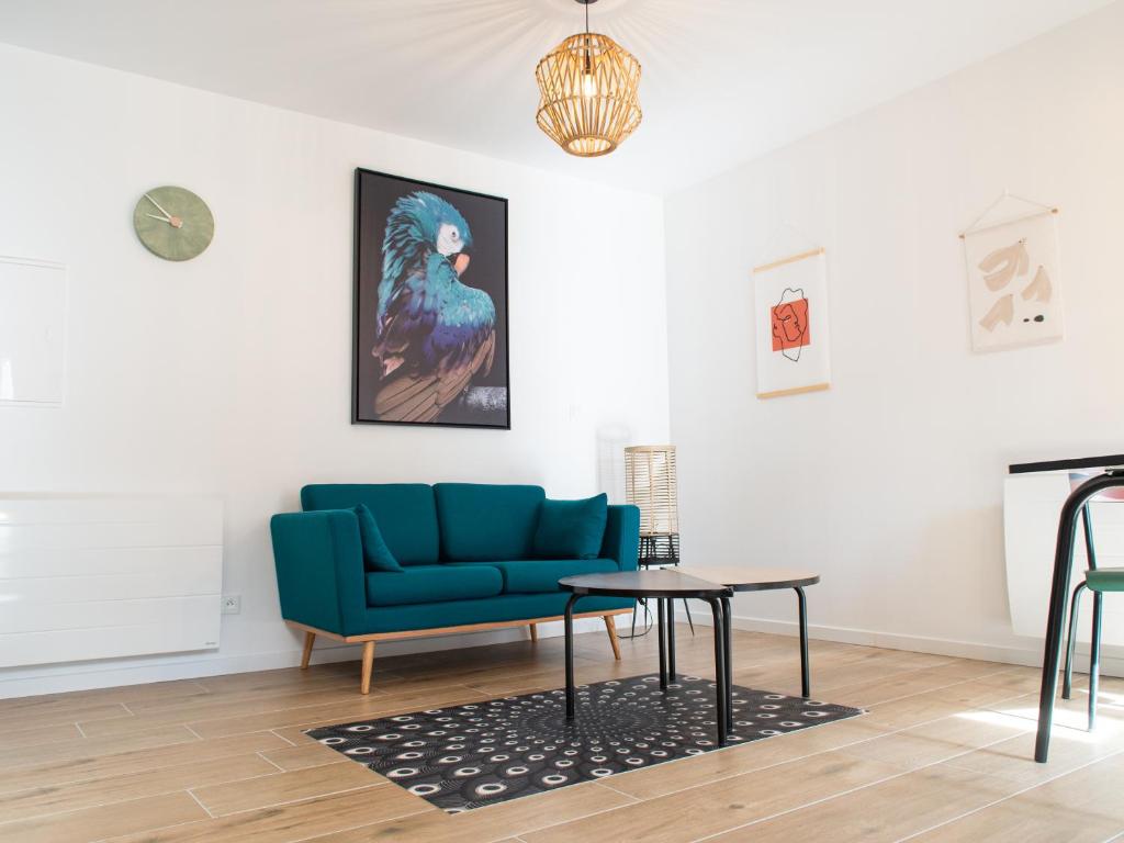 ein Wohnzimmer mit einem blauen Sofa und einem Tisch in der Unterkunft Le Saunerie - Sleep in Sisteron in Sisteron