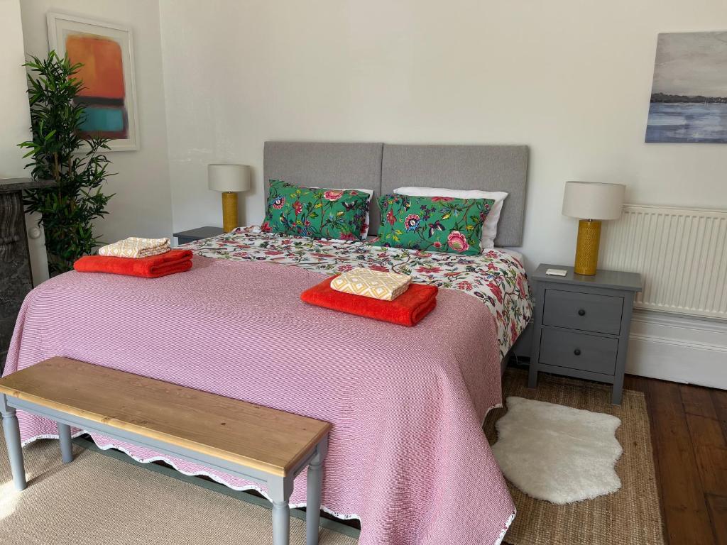 a bedroom with a large bed with a pink blanket at Elegant Bloomsbury Apartment in Tunbridge Wells in Royal Tunbridge Wells