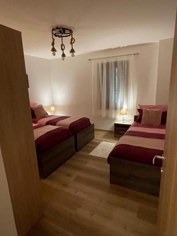 sypialnia z 2 łóżkami, oknem i żyrandolem w obiekcie Casa Rodi w mieście Siror