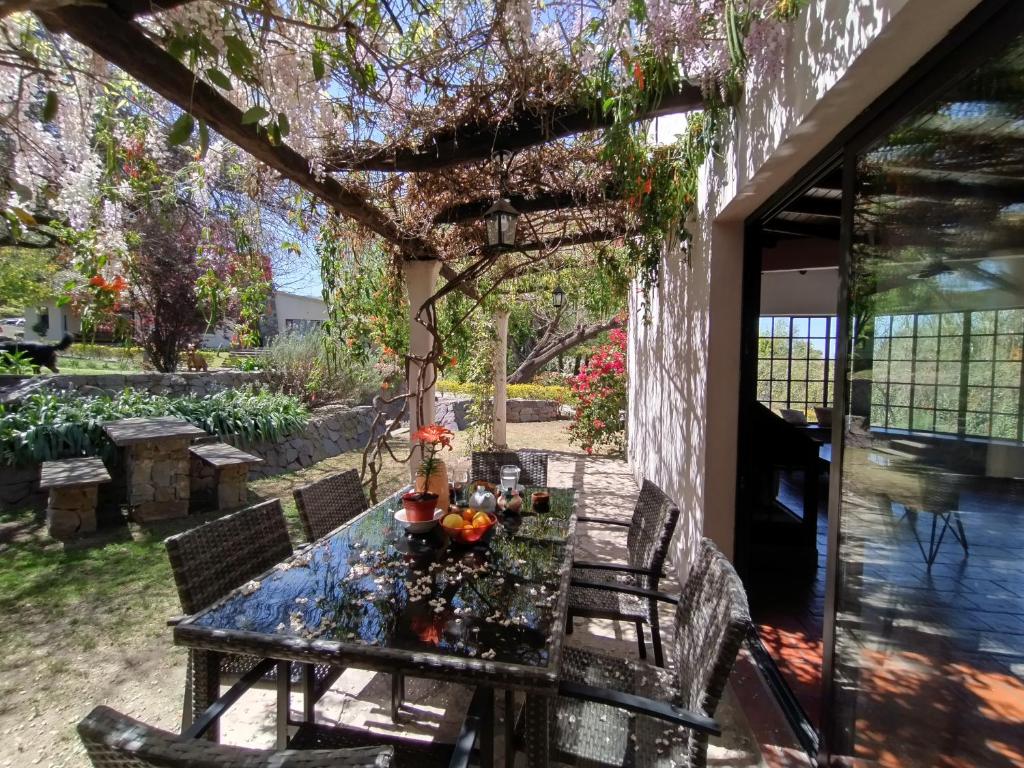 a table on the back porch of a house at CampoMora- 5 min del Centro - CONFORT - Parrilla & Pileta in San Salvador de Jujuy