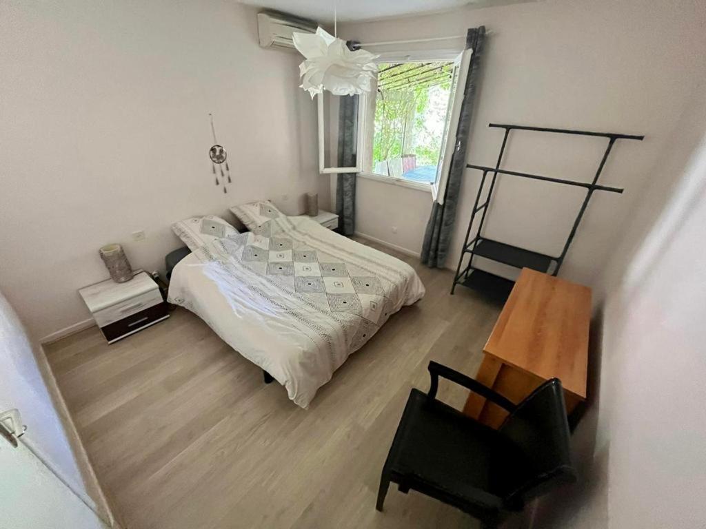 sypialnia z łóżkiem, krzesłem i oknem w obiekcie Belle et grande villa pour des séjours en famille et entre amis w mieście Cruscades