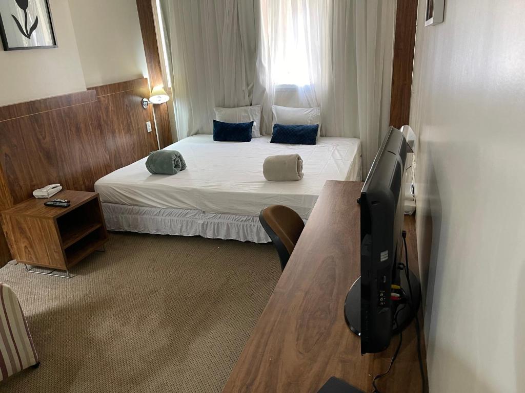 a hotel room with a bed and a television at PROMOÇÃO EXECUTIVA COM BANHEIRA E FLATS SEM BANHEIRA- Melhor Hotel De Taguatinga in Taguatinga