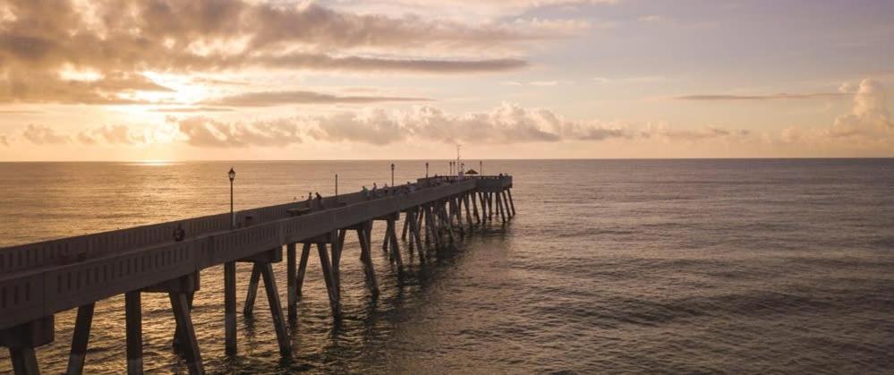 een pier strekt zich uit over de oceaan met zonsondergang bij Cottage by the Beach Best Suited for Large Groups in Wilmington