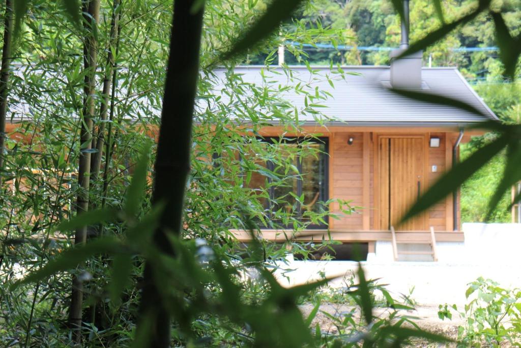 una cabaña de madera en el bosque con árboles en NEXX IKI - Vacation STAY 16966v, en Iki