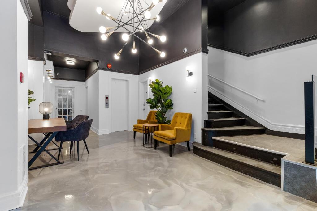 a lobby with a staircase and a table and chairs at Le Sand & Stone Hotel in Montreal