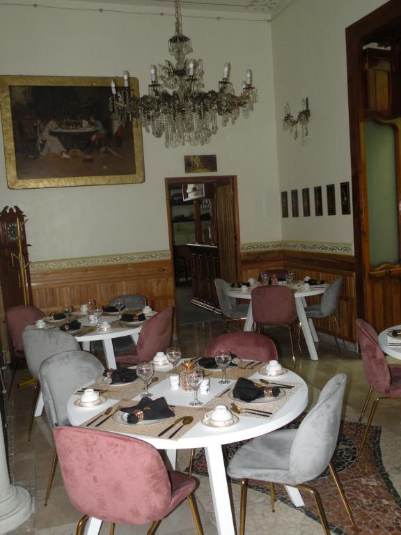 een eetkamer met tafels en stoelen en een kroonluchter bij Azcami Boutique Hotel in Puebla