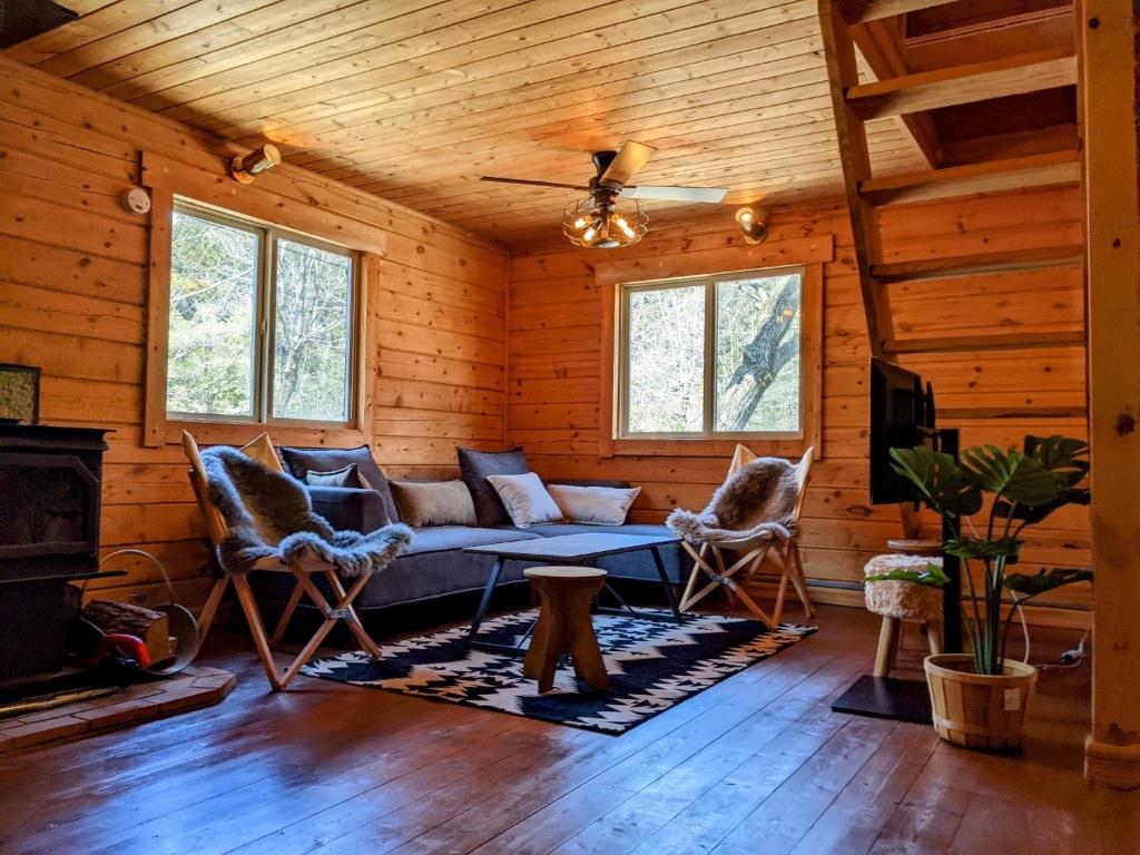 a living room with a couch and chairs in a log cabin at Ittoukashi no resort log house Piilo - Vacation STAY 36167v in Takashima