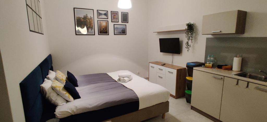 mała sypialnia z łóżkiem i kuchnią w obiekcie 4 Kąty Koronowo w mieście Koronowo