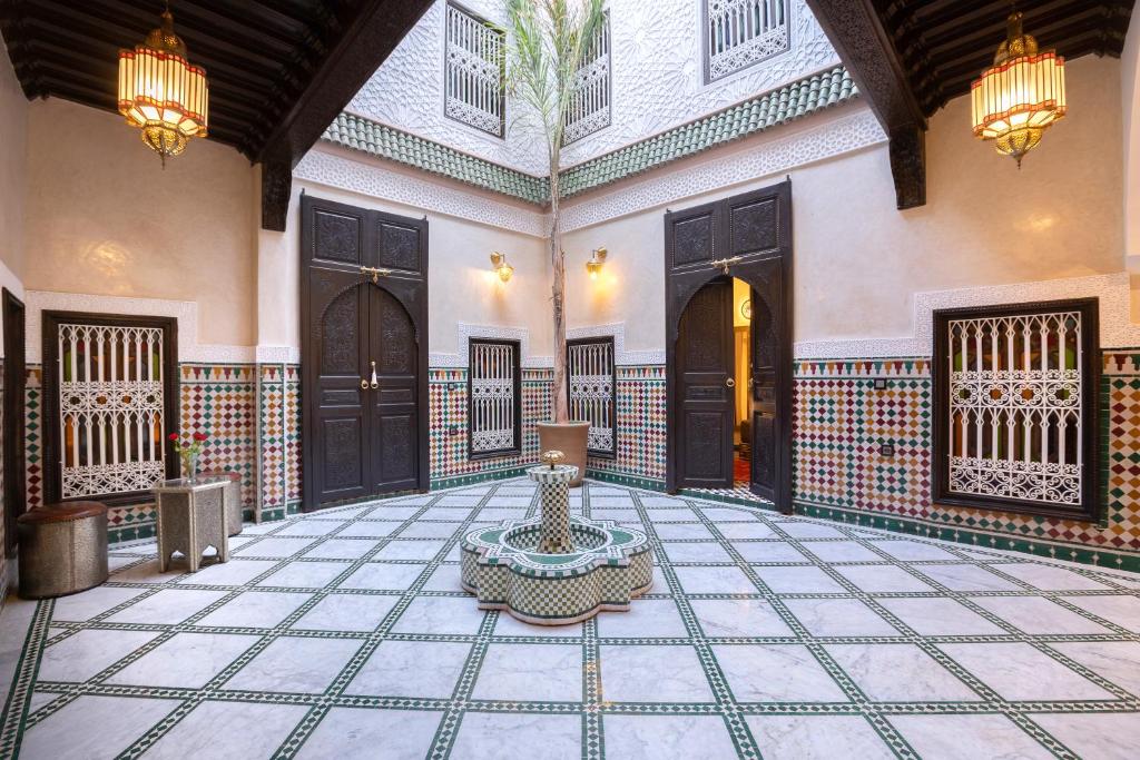 un patio con una fuente en el medio de un edificio en Riad Mazaj, en Marrakech