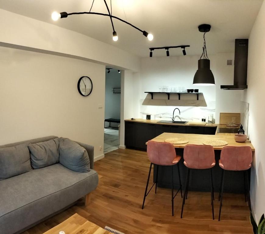 uma sala de estar com um sofá, uma mesa e cadeiras em Apartament Słoneczny 2 em Sanok