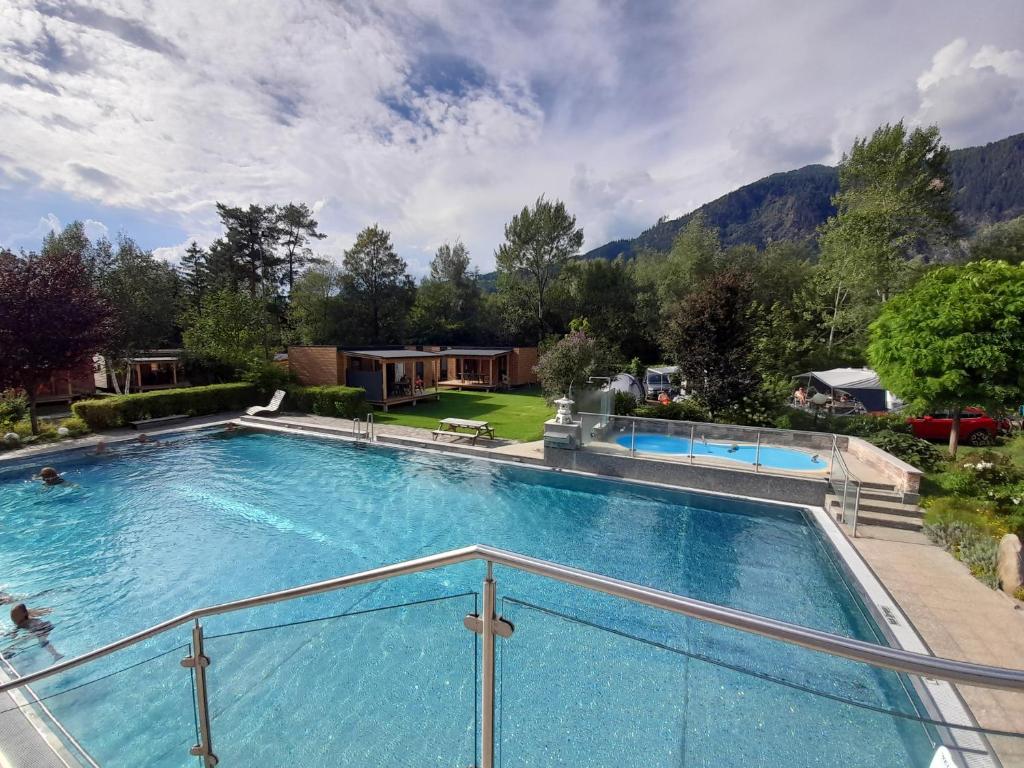 a large swimming pool with mountains in the background at Schwimmbad Camping Mössler in Döbriach