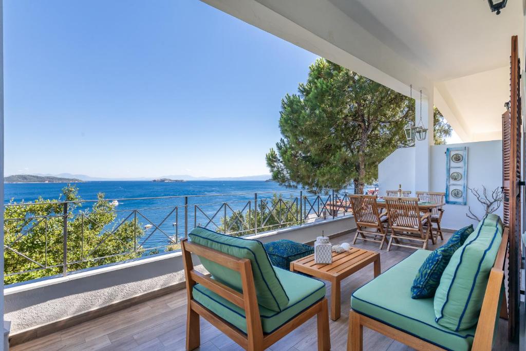 a room with a balcony with a view of the ocean at The Sea House Skiathos in Skiathos