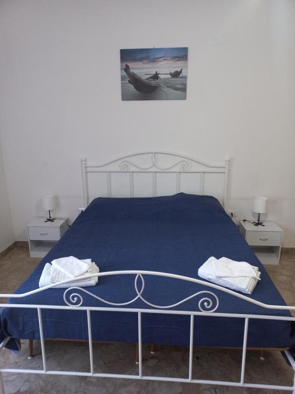 een slaapkamer met een blauw bed en 2 nachtkastjes bij B&B villa Sofia in Montecosaro