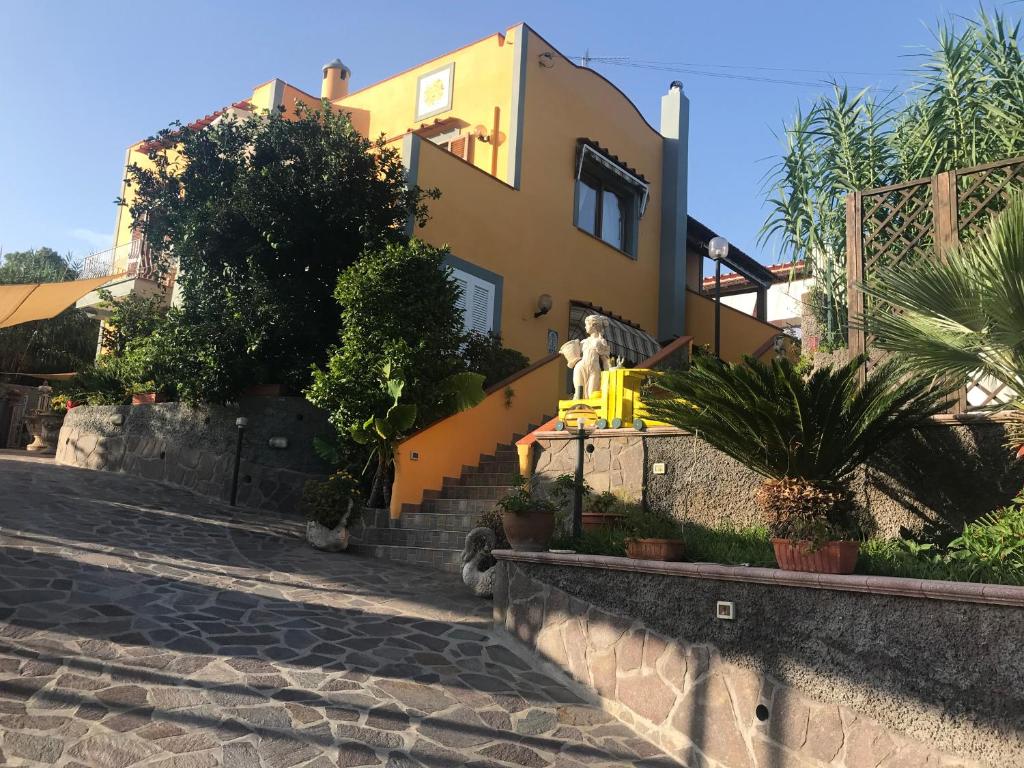 una casa gialla con le scale di fronte di Mario’s House a Ischia