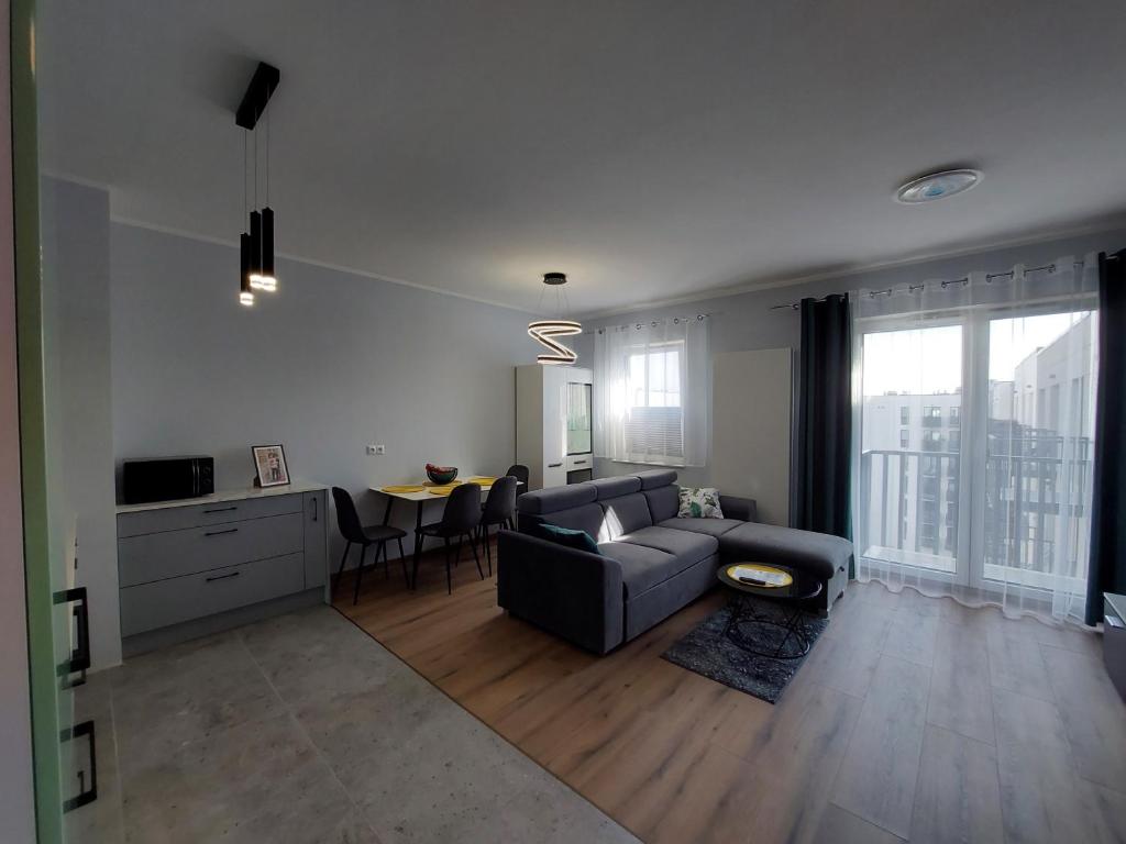een woonkamer met een bank en een tafel bij Kamienica Nova VITORE 116 in Szczecin