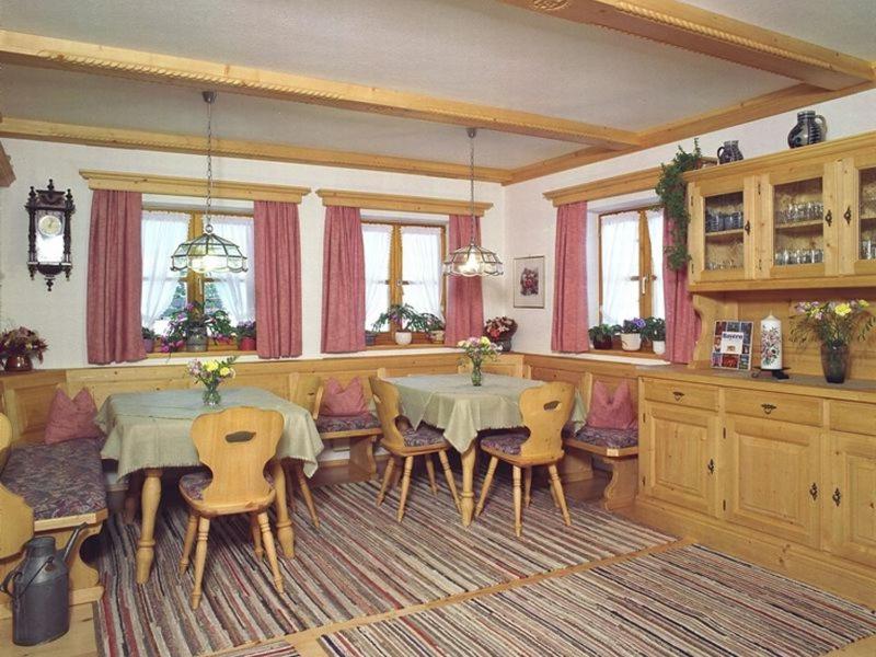 uma sala de jantar com duas mesas e cadeiras em Knapphof em Reit im Winkl