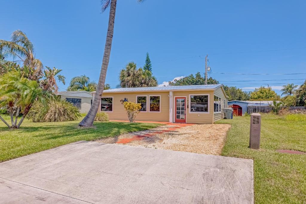 a house with a palm tree in front of it at Sunshine Escape in Vero Beach