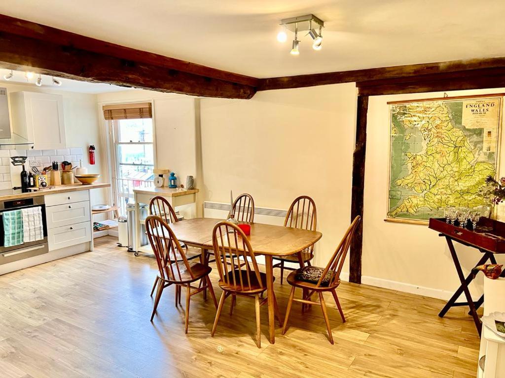 a kitchen and dining room with a table and chairs at Charming 2 bed flat market square in Oxfordshire in Grove