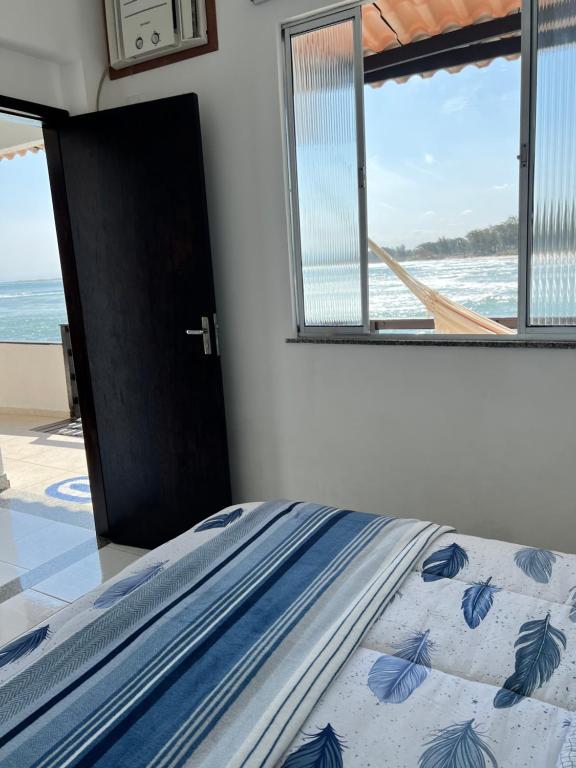 a bedroom with a bed with a view of the ocean at Casa Marambaia 2 in Rio de Janeiro