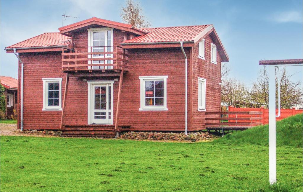 a red brick house with white windows on a yard at Gorgeous Home In Ustronie Morskie With Kitchen in Ustronie Morskie